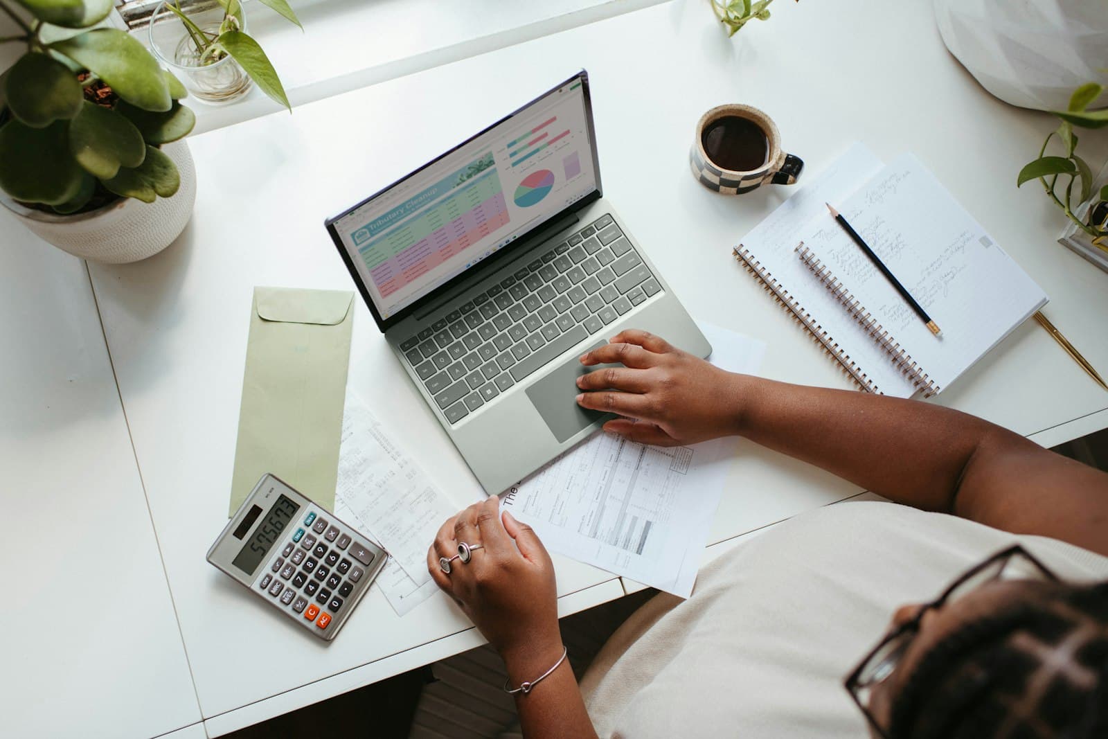 Business owner working at a table with a laptop to track business expenses